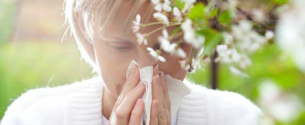 Protégez-vous contre les nuisances du printemps​ -Effets des allergies saisonnières : une femme se mouche en raison de la présence de pollen dans l'air.